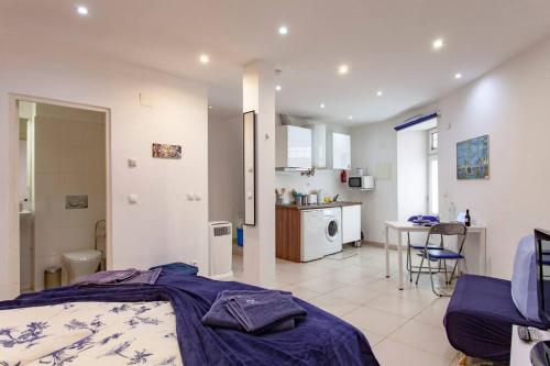 a bedroom with a bed and a kitchen with a table at Alfama IV in Lisbon
