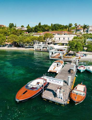 two boats are docked at a dock in the water at Hotel Ristorante Sogno in San Felice del Benaco