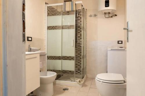 Un baño con inodoro y ducha de cristal. en Villa Badia a Ruoti, en Badia a Ruoti