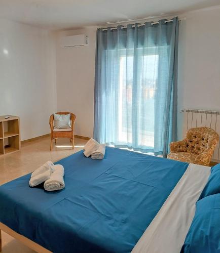 a bedroom with a blue bed with two towels on it at Casa Nina in Putignano