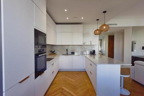 - une cuisine blanche avec des placards blancs et une table dans l'établissement Rare luxury 3-Br near the Croisette, à Cannes