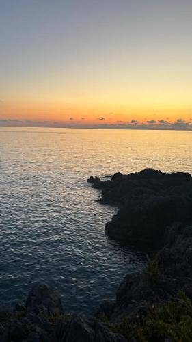 a sunset over a body of water with rocks at I delfini in Scalea