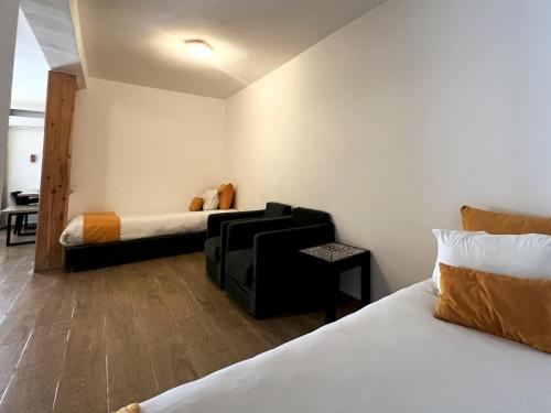 a room with two beds and a chair in it at HAMILTON Agadir in Agadir