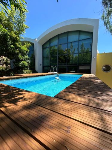 a swimming pool in front of a house at Arrábida Resort in Quinta do Anjo