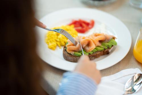 a person is eating a plate of breakfast food at La Fe Boutique Hotel Sarande in Sarandë