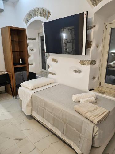 a white bedroom with a bed and a mirror at Aristotelis Homes in Katapola