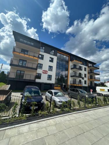 a building with cars parked in front of it at Premium Apartament Koronowska 40m2 in Bydgoszcz