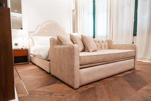 a couch in a living room with a bed at La Fe Boutique Hotel Sarande in Sarandë