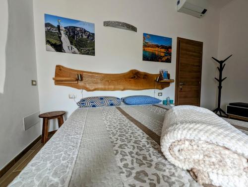 una camera da letto con un letto grande con testiera in legno di Agriturismo Caruggiu di via vecchia a Orco Feglino