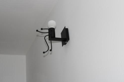 a black lamp on a white wall at Appartment Herzblick in Sankt Georgen im Gailtal