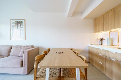 a living room with a wooden table and a couch at Résidence Ibaïa - Piscine & Spa in Hendaye