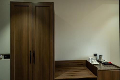a wooden cabinet in a room with a counter at Hotel Mivaante in Ahmedabad