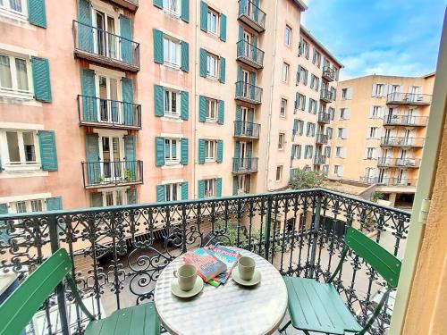 - une table et des chaises sur un balcon avec des bâtiments dans l'établissement Nestor&Jeeves - PLACE DU PIN - Near Port - Old town, à Nice