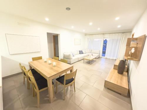 a dining room and living room with a table and chairs at Villa Verano in Cala Galdana