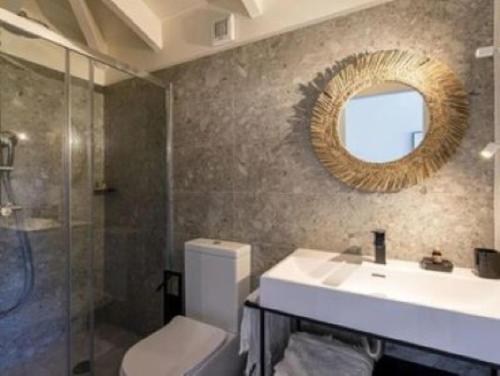 une salle de bain avec un lavabo et un miroir et des toilettes dans l'établissement LE PETIT DOMAINE DE SPERONE, à Bonifacio