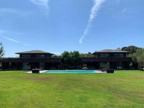 un bâtiment avec une piscine dans un champ dans l'établissement LE PETIT DOMAINE DE SPERONE, à Bonifacio