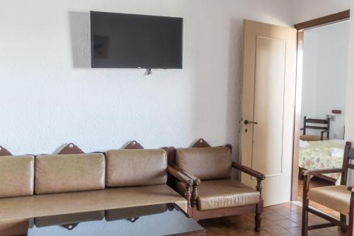 a living room with a couch and a television on the wall at Hotel Malia Holidays in Malia