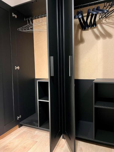 a black closet with black cabinets and hangers at Udine Station Apartment in Udine