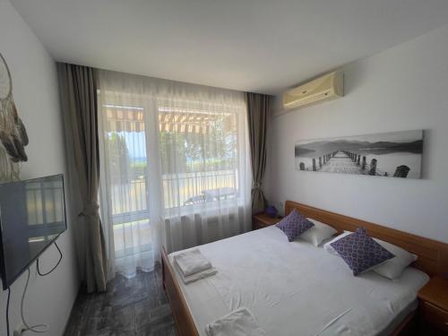 Un dormitorio con una cama y una ventana grande. en Fort Noks SP apartments-Elenite, en Elenite