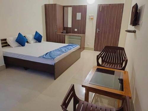 a bedroom with a bed and a table and a chair at The Urban Escape in Guwahati