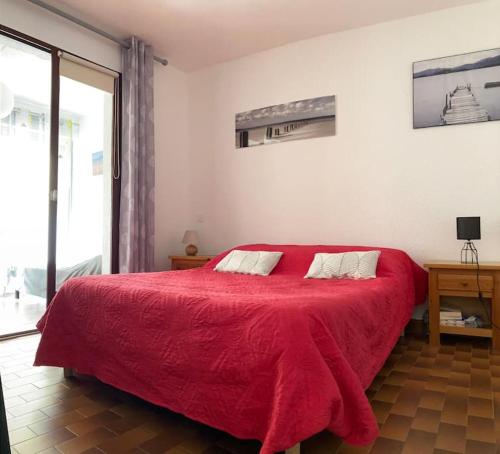- une chambre avec un lit rouge et une couverture rouge dans l'établissement Apt T2 bis, Relax en front de mer, piscine à Port Leucate, à Leucate