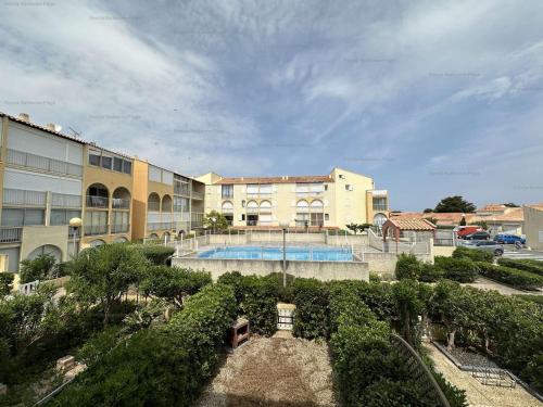 - une vue sur un bâtiment avec piscine dans l'établissement Appartement 2 pièces avec loggia, piscine et parking privé à 250m des commerces et proche plage - FR-1-229B-74, à Narbonne