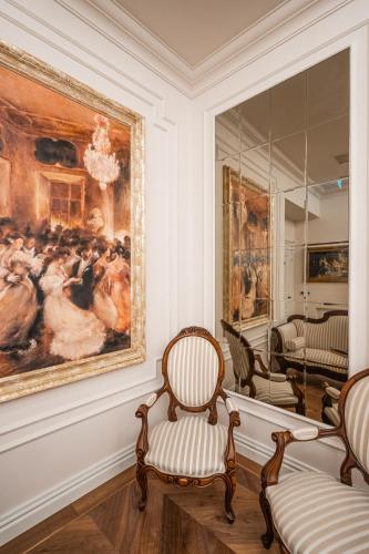 a room with two chairs and a painting on the wall at La Fe Boutique Hotel Sarande in Sarandë