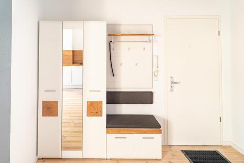 Cette chambre comprend un placard blanc avec un banc. dans l'établissement Eismöwe, à Barth