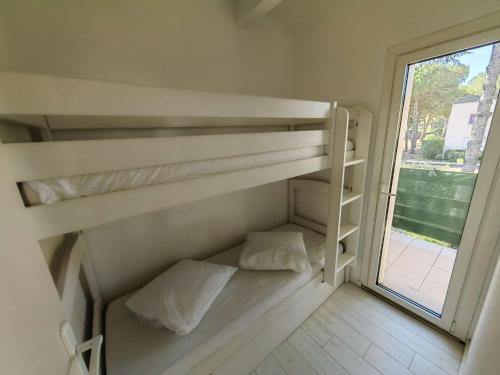 deux lits superposés dans une chambre avec fenêtre dans l'établissement Studio cabine rénové 4 pers. avec piscine, parking privé, proche mer et village naturiste - FR-1-607-193, au Cap d'Agde