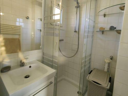 une salle de bain blanche avec une douche et un lavabo dans l'établissement Studio cabine rénové 4 pers. avec piscine, parking privé, proche mer et village naturiste - FR-1-607-193, au Cap d'Agde
