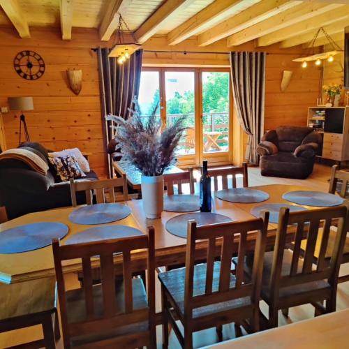 a living room with a wooden table and chairs at Zacisze na Wzgórzu in Zawoja