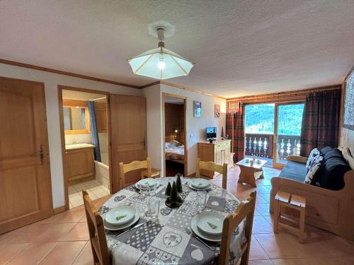 une salle à manger avec une table et un canapé dans l'établissement Appartement cosy 5 pers à 20m des pistes et commerces, balcons, parking couvert - FR-1-180-601, à Les Allues