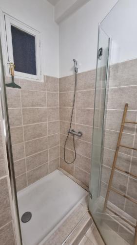 une salle de bain avec une douche avec une porte vitrée dans l'établissement Grand T2 surplombant le Vieux Port Marseille, à Marseille