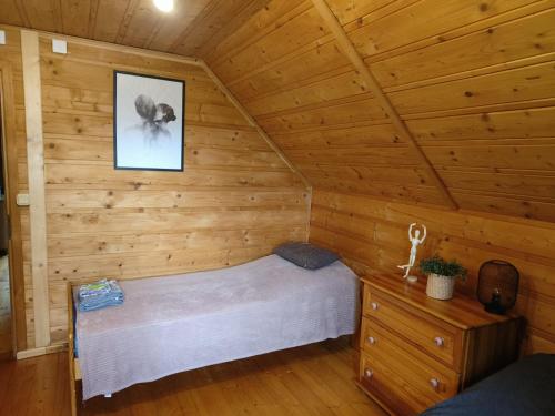 a room with a bed in a log cabin at Zacisze na Wzgórzu in Zawoja