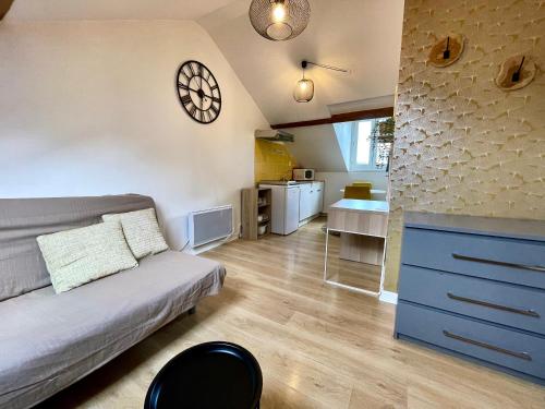 un salon avec un canapé et une horloge au mur dans l'établissement Cosy studio,Mutualiste,Belle Electrique, à Grenoble