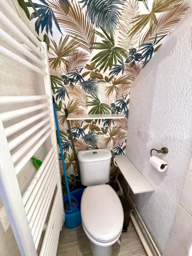 une salle de bain avec toilettes et papier peint palmier dans l'établissement Cosy studio,Mutualiste,Belle Electrique, à Grenoble