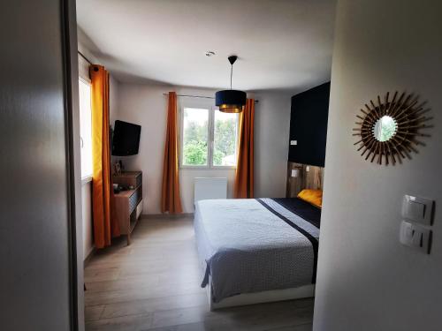 une chambre avec un lit et un miroir au mur dans l'établissement La Bastide Provençale, à Pourrières