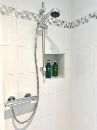 a shower with a shower head in a bathroom at Coom Cottage in Gneevgullia