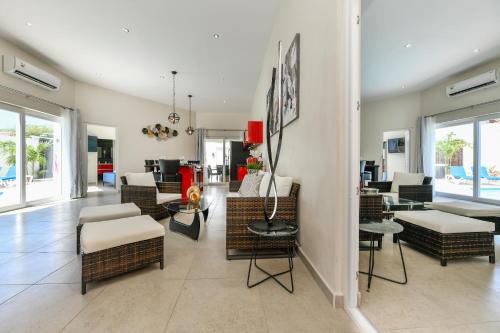 una sala de estar con sillas y mesas de mimbre en Swiss Paradise Aruba Luxury Collection, en Palm-Eagle Beach