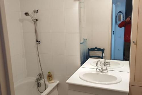 une salle de bain blanche avec un lavabo et une douche dans l'établissement Appartement face à la mer, à Criel-sur-Mer