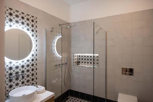 a bathroom with a sink and a shower with a mirror at Apartmány Marienhof in Znojmo