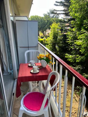 a red table and chairs on a balcony at Cros de Cagnes, apartment with the Best Location in Cagnes-sur-Mer