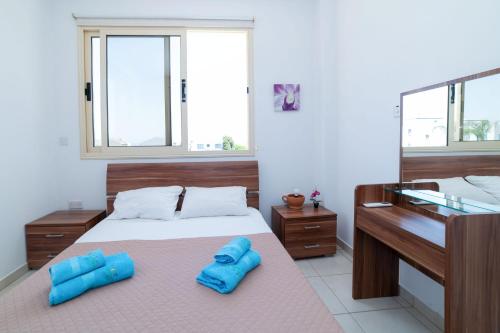 ein Schlafzimmer mit einem Bett mit blauen Kissen darauf in der Unterkunft Villa Anna Maria, Kapparis in Paralimni