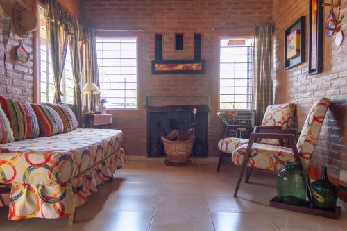 a living room with a couch and a fireplace at Complejo Utopia-Chacras de la Primavera, Tanti in Tanti