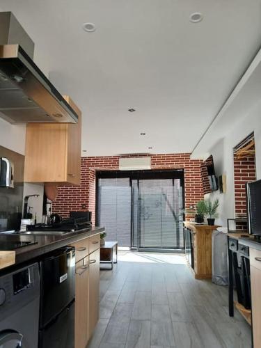 une grande cuisine avec un mur de briques et une grande fenêtre dans l'établissement Disneyland Paris Studio avec Terrasse, à Chalifert