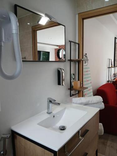 une salle de bain avec un lavabo blanc et un miroir dans l'établissement Disneyland Paris Studio avec Terrasse, à Chalifert