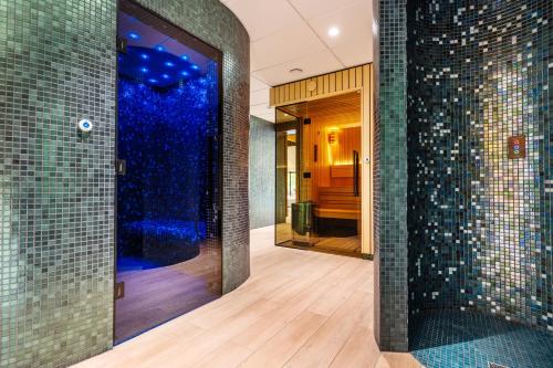a bathroom with a shower with blue tiles at Ośrodek Wypoczynkowy Łańsk in Stawiguda