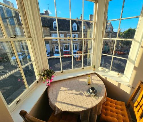 a table in a room with large windows at Private Woody Apartment, 2 King Beds, Very Centre Stamford in Lincolnshire