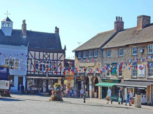 a group of people walking down a city street with buildings at Private Woody Apartment, 2 King Beds, Very Centre Stamford in Lincolnshire