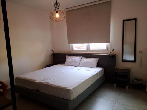 a bedroom with a white bed with a window at St Elena Boutique Residence in Larnaka